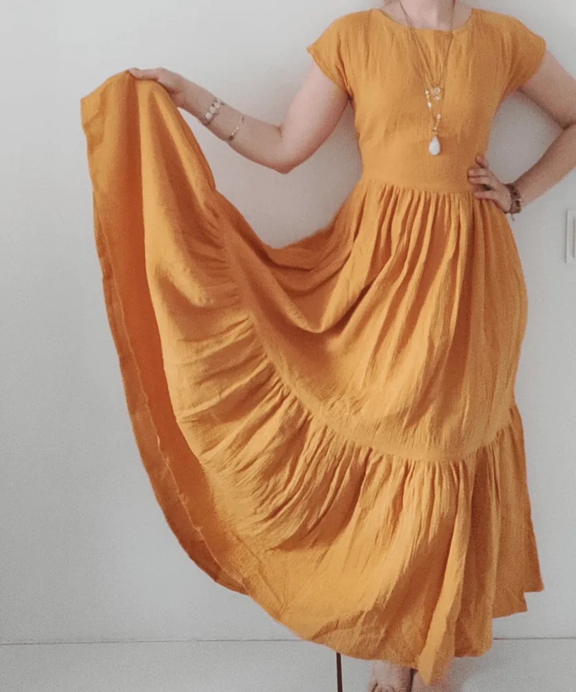 Kollase musliinist boho kleidi detailvaade langevast kangast ja volditud osast
